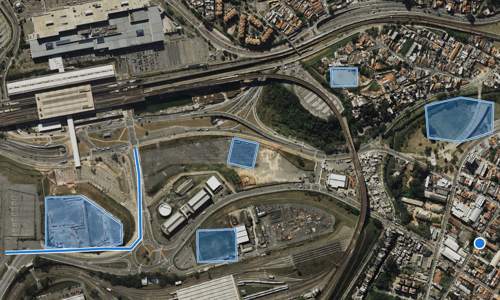Mapa de um bairro sobre ortofoto com várias obras marcadas por polígonos azuis